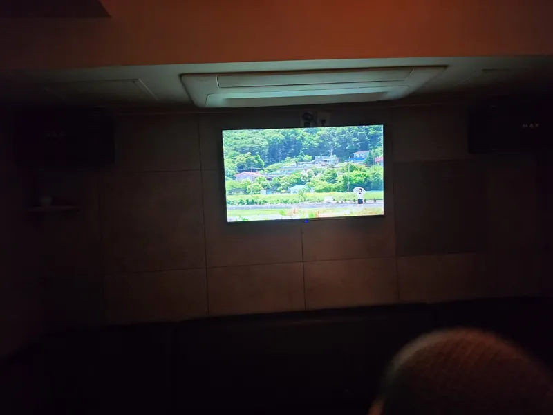 조명을 낮춘 룸의 대형 노래방 화면